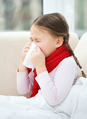 Image showing Little girl is blowing her nose