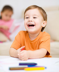 Image showing Little boy is drawing on white paper