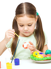 Image showing Little girl is painting eggs preparing for Easter