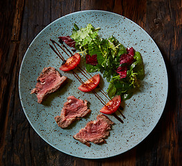 Image showing Grilled sliced roast beef and green salad