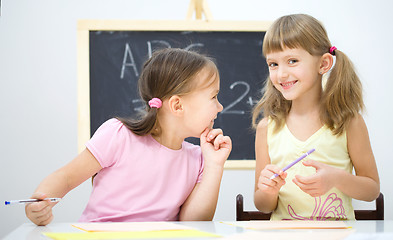 Image showing Little girls are writing using a pen