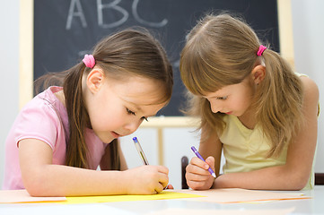 Image showing Little girls are writing using a pen