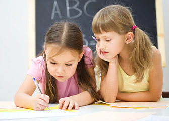 Image showing Little girls are writing using a pen