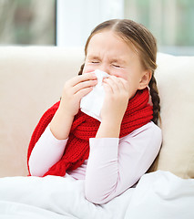 Image showing Little girl is blowing her nose