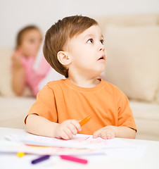 Image showing Little boy is drawing on white paper