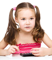 Image showing Little girl is using calculator