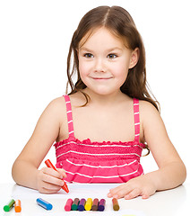 Image showing Little girl is drawing using colorful crayons