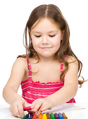 Image showing Little girl is drawing using colorful crayons