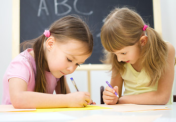 Image showing Little girls are writing using a pen