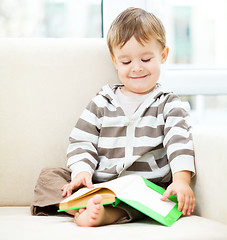 Image showing Little boy is reading book