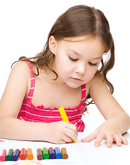 Image showing Little girl is drawing using a crayons