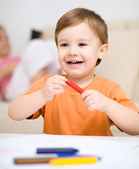 Image showing Little boy is drawing on white paper