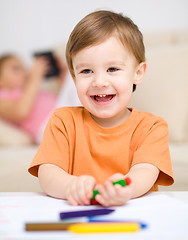 Image showing Little boy is drawing on white paper