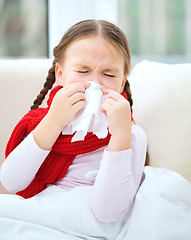 Image showing Little girl is blowing her nose