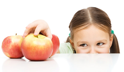 Image showing Little girl is reaching apple