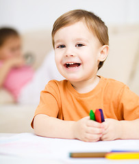 Image showing Little boy is drawing on white paper