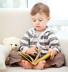 Image showing Little boy is reading book