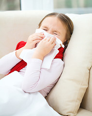 Image showing Little girl is blowing her nose