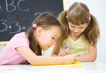 Image showing Little girls are writing using a pen