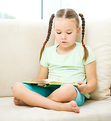 Image showing Little girl reads a book