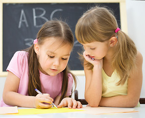 Image showing Little girls are writing using a pen