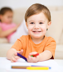 Image showing Little boy is drawing on white paper