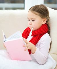 Image showing Ill little girl with thermometer is reading book