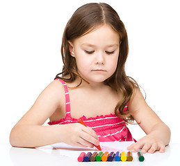 Image showing Little girl is drawing using a crayon