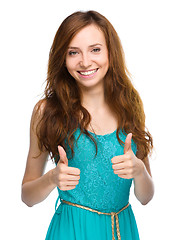 Image showing Woman is showing thumb up gesture