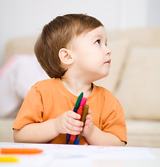 Image showing Little boy is drawing on white paper