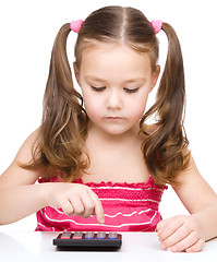 Image showing Little girl is using calculator