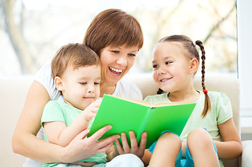 Image showing Mother is reading book for her children