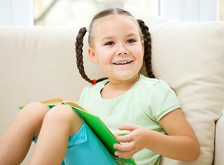 Image showing Little girl reads a book