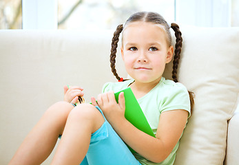 Image showing Little girl reads a book