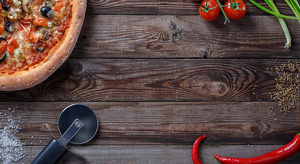 Image showing Tasty pizza with ingridients on a wooden board.