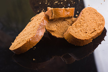 Image showing sliced bread on dark glass background