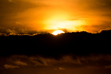 Image showing sunset with sun clouds over clouds