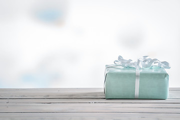 Image showing Gift in blue color on a wooden table