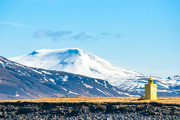 Image showing Small lighthouse on an island with mountains