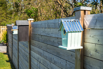 Image showing Bird houses on a row at a fence