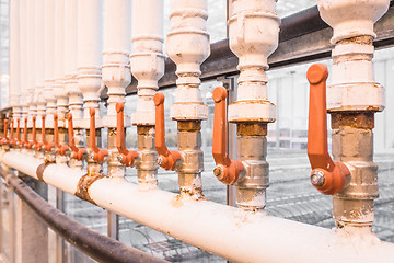 Image showing Orange handles on white pipes