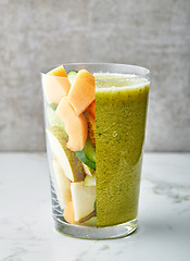 Image showing glass of smoothie and fruit pieces