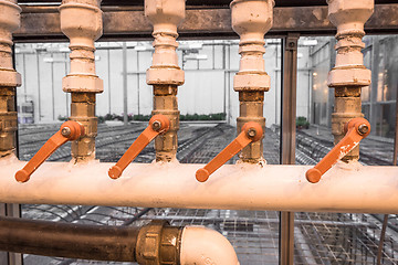 Image showing Old pipes with orange handles
