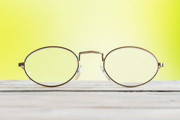 Image showing Glasses on a table on green background