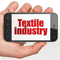 Image showing Industry concept: Hand Holding Smartphone with Textile Industry on display