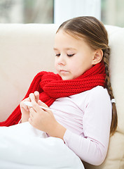 Image showing Ill little girl is reading thermometer