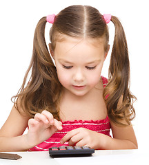 Image showing Little girl is using calculator