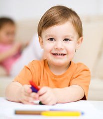 Image showing Little boy is drawing on white paper