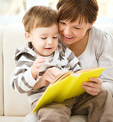 Image showing Mother is reading book for her son