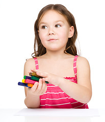 Image showing Little girl is drawing using colorful crayons